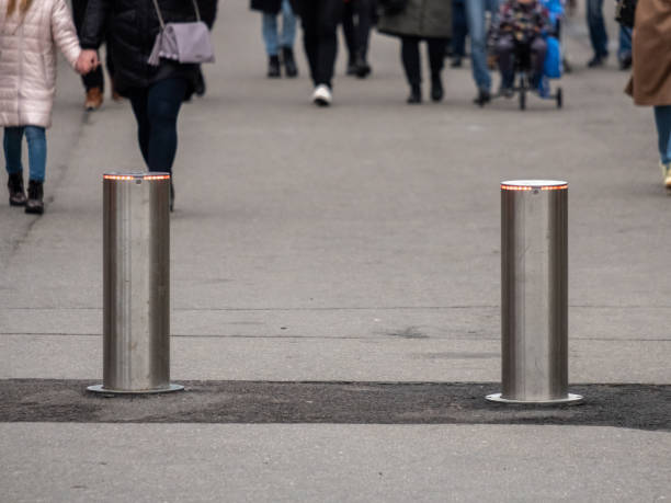 istock Automatic cylindrical barriers on the pedestrian zone against the background of blurry feet of pedestrians. 1185641314