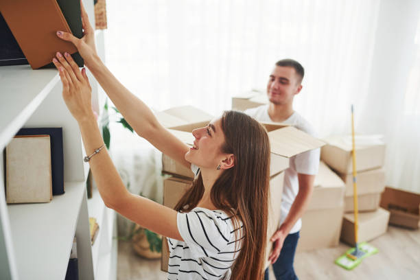 istock Every book must be in it's right place. Cheerful young couple in their new apartment. Conception of moving 1185641327
