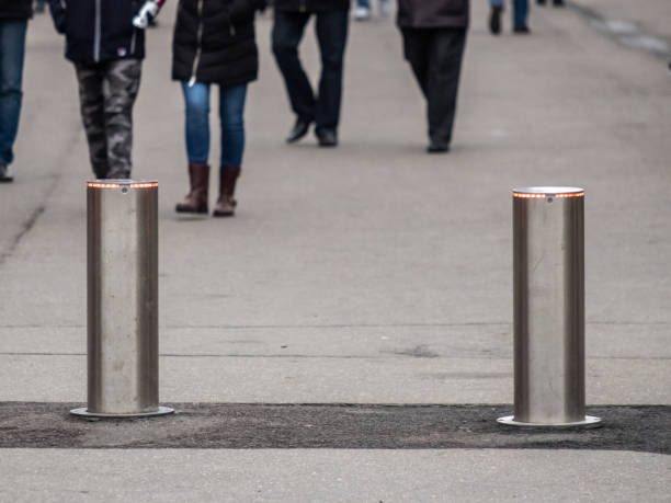 istock Automatic cylindrical barriers on the pedestrian zone against the background of blurry feet of pedestrians. 1185641358