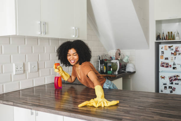 A clean home is a happy home Cropped shot of a young woman wearing rubber gloves while cleaning her home kitchen worktop cleaning stock pictures, royalty-free photos & images