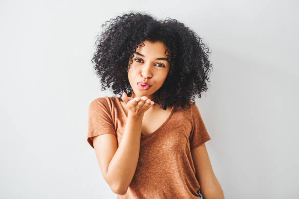 You deserve the good that's coming your way Cropped shot of an attractive young woman posing against a grey background blowing a kiss stock pictures, royalty-free photos & images