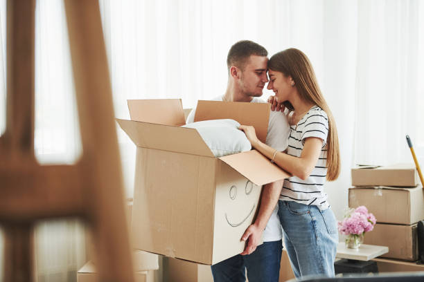 istock Box with smile painted on it. Cheerful young couple in their new apartment. Conception of moving 1185641787