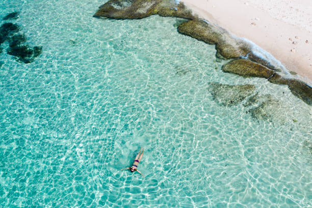istock Bali, woman floating in transparent turquoise sea. Aerial drone shot. 1185643632