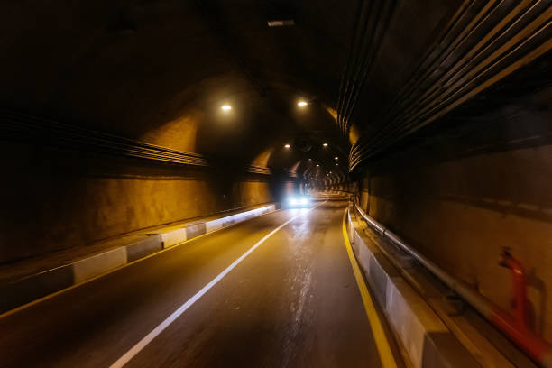 istock Road tunnel in mountain illuminated by lamps 1185644288