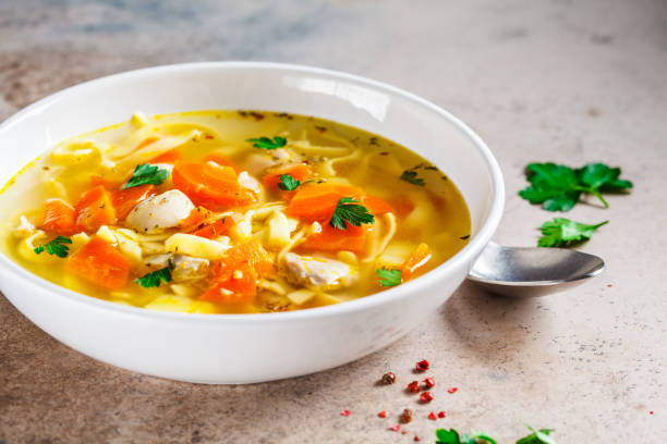 istock Chicken soup with noodles, parsley and vegetables in a white plate. 1185644472