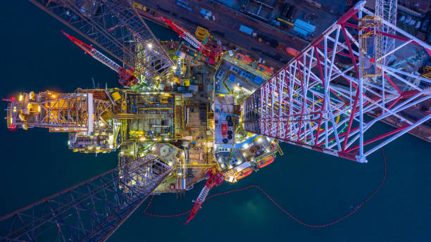 vista aerea offshore jack up rig di notte, piattaforma di perforazione di piattaforme petrolifere offshore. - oil derrick crane crane exploration foto e immagini stock