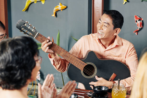 istock Man playing guitar fro friends and relatives 1185646827