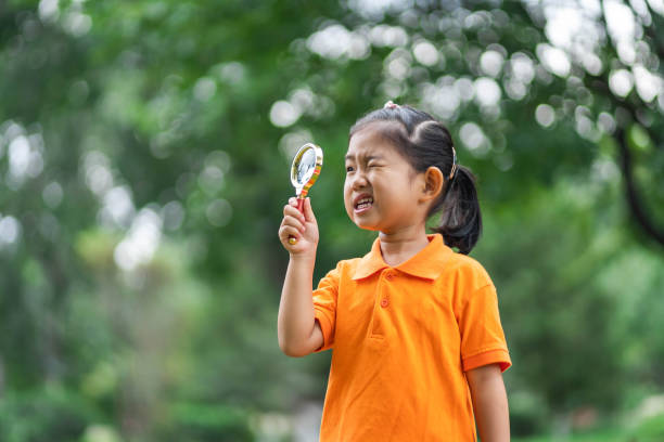 istock Girl uses magnifying glass discover and explore 1185647609