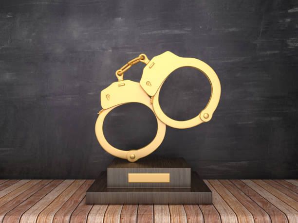 trofeo con esposas en suelo de madera - fondo de pizarra - renderizado 3d - golden handcuffs fotografías e imágenes de stock