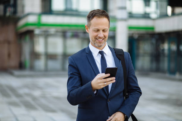 istock Businessman reading text message on mobile phone outdoors 1185649263