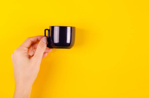 istock Hand with dark thermos composition on yellow background. 1185650272