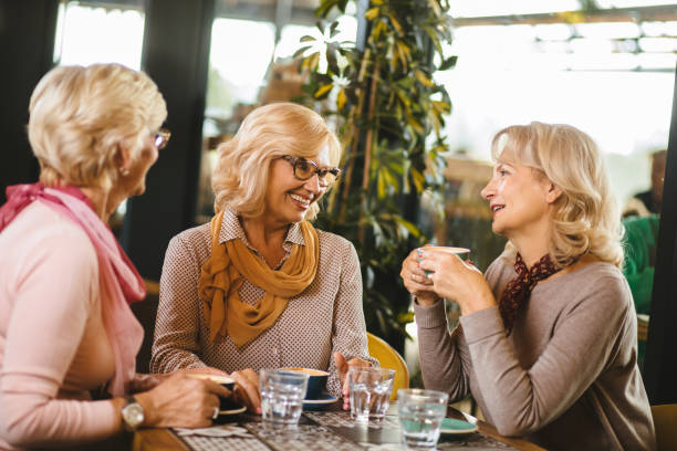 istock Three senior ladies socializing over coffee in cafe 1185651199