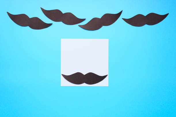 istock Several black paper moustache and writing paper sticker on a blue background. The concept of awareness of men's health and prostate cancer. Space for text 1185652321