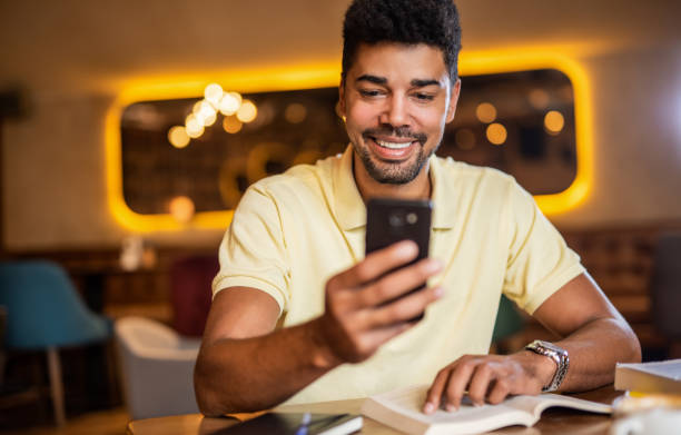 istock Happy male student texting a message in coffee shop. 1185652412