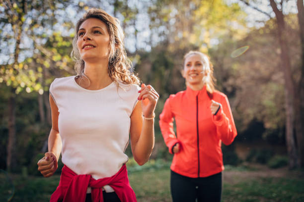 istock Two ladies jogging in nature 1185654247