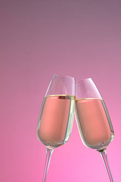 istock two glasses of sparkling wine on a pink background 1185654406