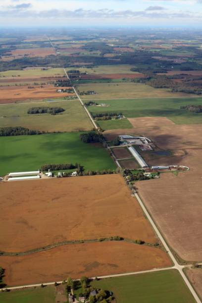 istock Looking down from airplane on rural fields and buildings 1185655863
