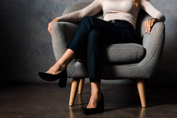 cropped view of businesswoman sitting on armchair in office cropped view of businesswoman sitting on armchair in office cross legged stock pictures, royalty-free photos & images
