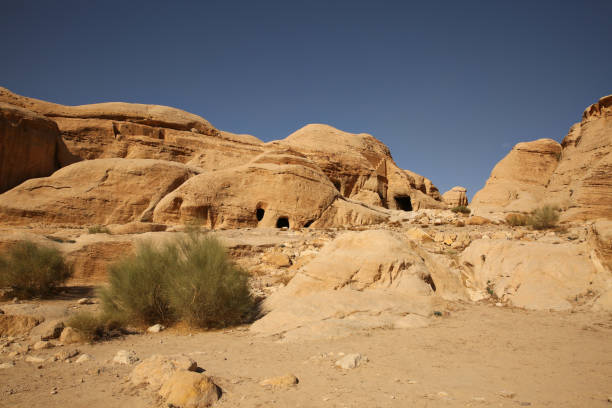 des habitations ou des maisons de caverne le long du chemin au siq, qui est le passage étroit de gorge que vous marchez le long pour atteindre petra, jordanie. - petra ancient civilization jordan cave photos et images de collection