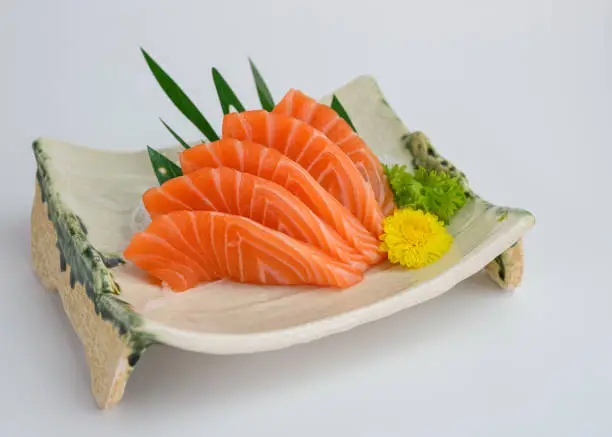 Sliced raw Salmon sashimi on ceramic plate