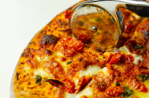 istock Cutting famous Neapolitan pizza based on buffalo mozzarella and tomatoes with a pizza cutter 1185660063