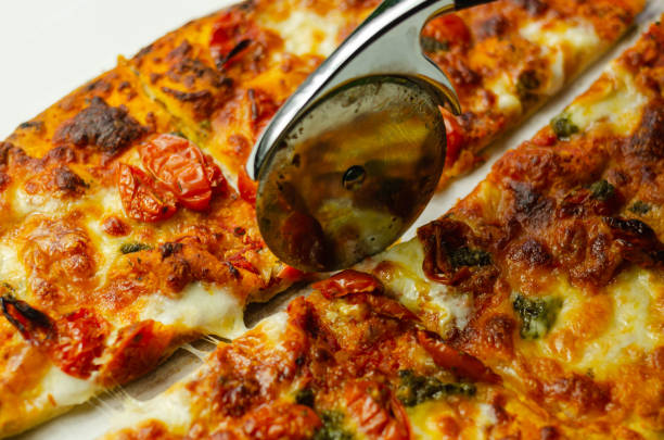 istock Cutting famous Neapolitan pizza based on buffalo mozzarella and tomatoes with a pizza cutter 1185660085
