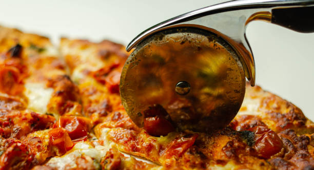 istock Cutting famous Neapolitan pizza based on buffalo mozzarella and tomatoes with a pizza cutter 1185660149