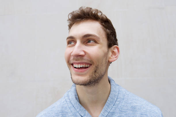 istock Close up happy young man smiling and looking away 1185660369