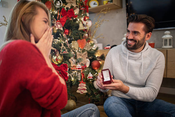 istock Beautiful young man proposing his girlfriend on christmas eve 1185662746