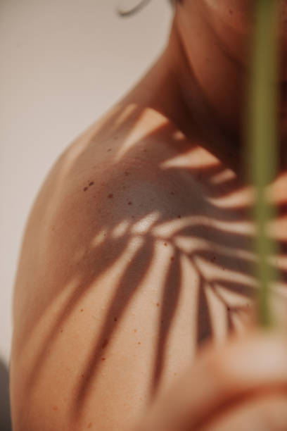 istock Shadow of palm tree on girl bare shoulder 1185663042