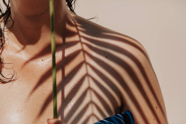 istock Shadow of palm tree on girl bare shoulder 1185663068