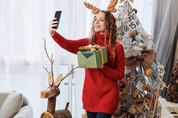 istock Lovely woman photographing with present 1185663146