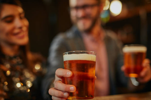 man giving beer to a friend. - irish culture beer drinking pub imagens e fotografias de stock