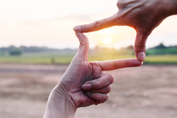 istock Hands of person make silhouette hand frame with sunset background. 1185664731