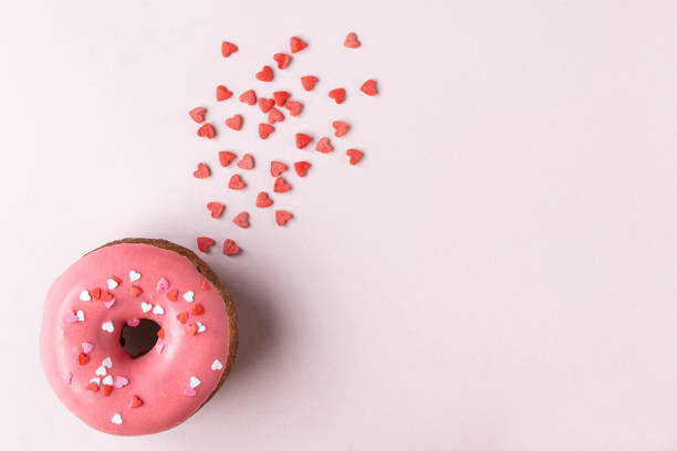 istock Donut with heart shaped decor on pink background. Top view with copy space 1185665714