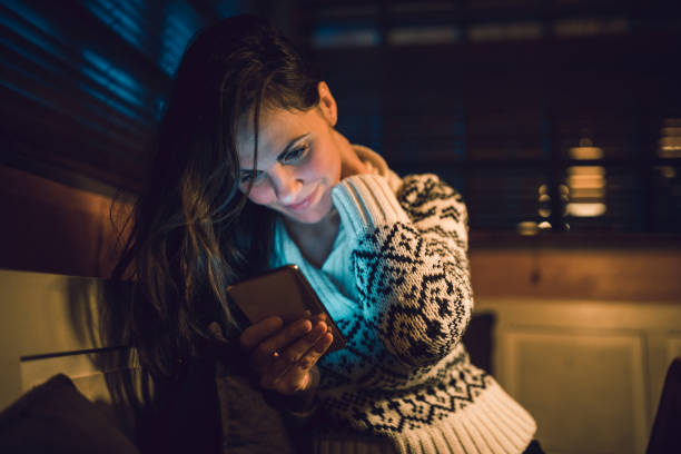 istock Beautiful woman using a mobile phone at night 1185666300
