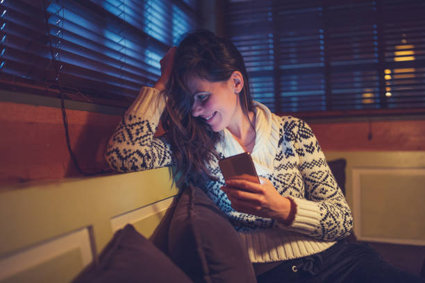istock Beautiful woman using a mobile phone at night 1185666304