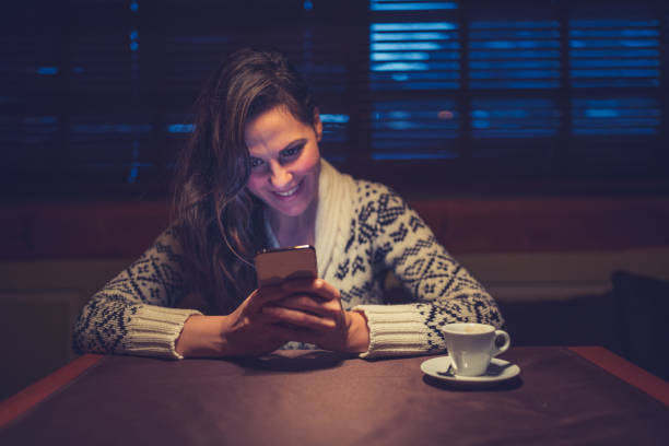 istock Beautiful woman using a mobile phone at night 1185666328