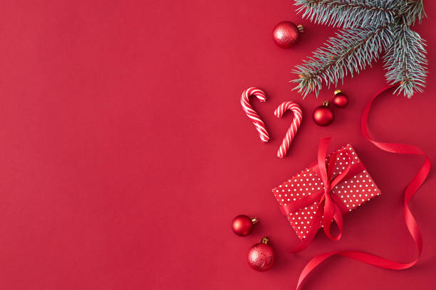 istock Flat lay border with branches spruce,christmas red balls and gift box on a red background 1185669559
