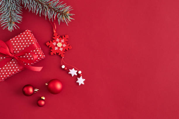 istock Flat lay border with branches spruce, red balls and christmas decoration on a red background 1185669585