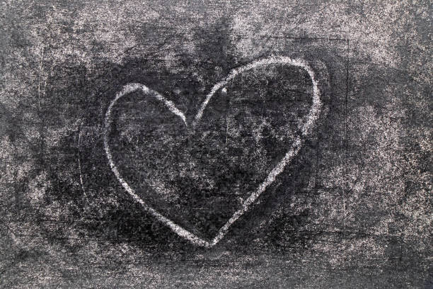 A red heart drawn with a lipstick on a pink paper. Love concept.