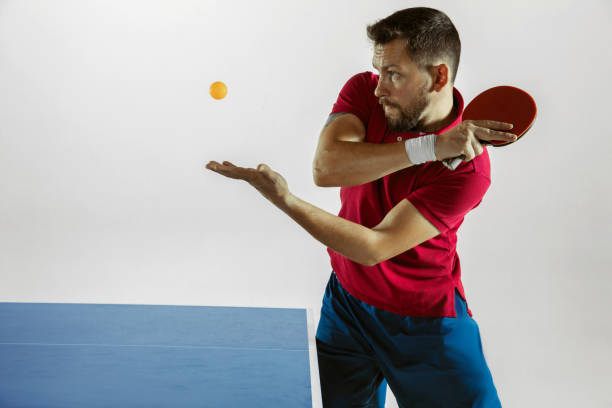 istock Young man playing table tennis on white studio background 1185672970