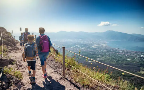 Photo of Family walking on the summit of Mount Vesuvius volcano in Campania, Italy.