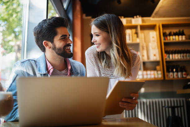 istock Young couple is working in cafe on laptop and smiling. 1185674511