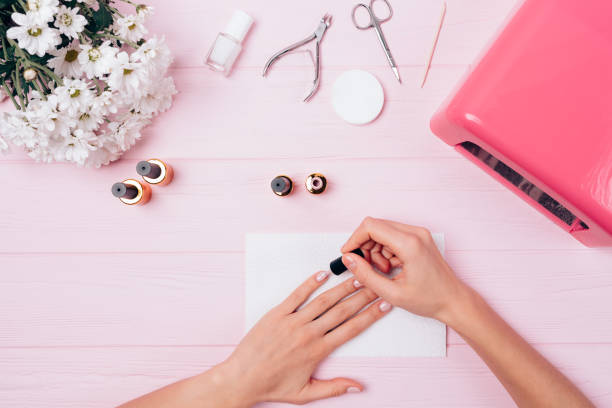 istock Woman doing manicure on a pink table 1185675015