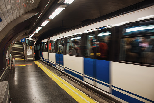 An underground train in motion at a station