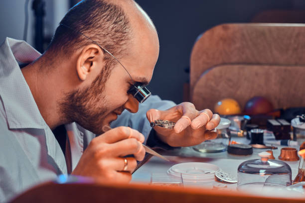 istock Mature clockmaster is fixing old watch for a customer at his busy repairing workshop 1185677913