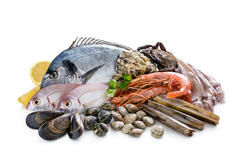 Food: group of healthy fresh raw seafood shot on white background. The composition includes fish, salmon steak, tuna steak, crab, shrimps, razor clams, mussels, oyster, squid and various clams. Predominant colors are red, brown and white. XXXL 42Mp studio photo taken with Sony A7rii and Sony FE 90mm f2.8 macro G OSS lens