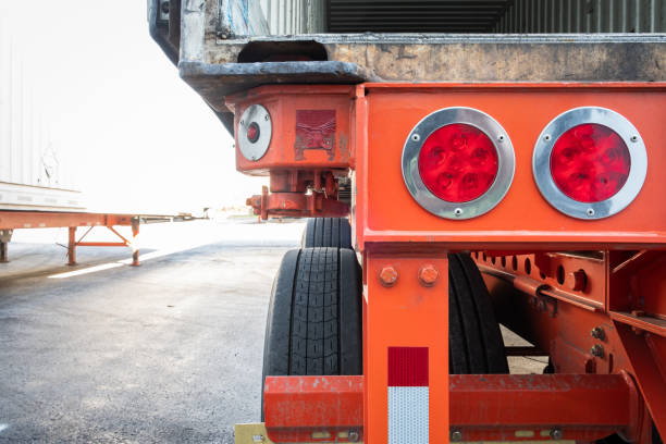 Section of rear part of commercial semi trailer with detail on wheels and signaling lights stock photo