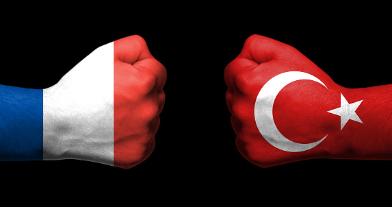 Flags of France and Turkey painted on two clenched fists facing each other on black background/ Denmark and Turkey relations concept